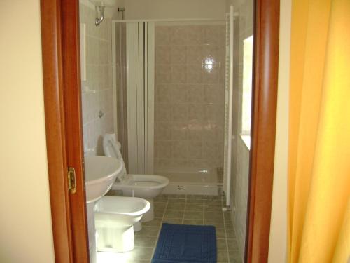 een badkamer met 2 toiletten, een wastafel en een douche bij The Wishing Well in Gallinaro