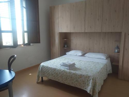 a bedroom with a bed and a table with books on it at Casa di Alfredo Affittacamere in Siena