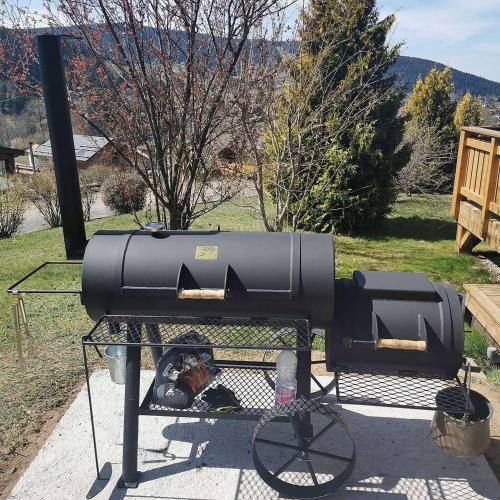 a bbq and a grill on a table at Nouveau Chalet M.META 12 pers sauna,jacuzzi,billard in Xonrupt-Longemer