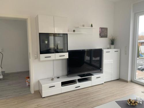 a large white entertainment center with a large flat screen tv at Ferienwohnung Maximilian in Grömitz