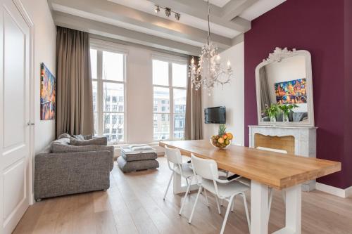 comedor con paredes de color púrpura, mesa y sillas en Residences Canal Area, en Ámsterdam