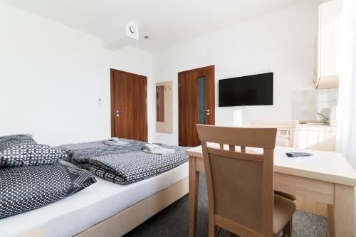 a bedroom with a bed and a table with a desk at Astra Apartments in Oświęcim