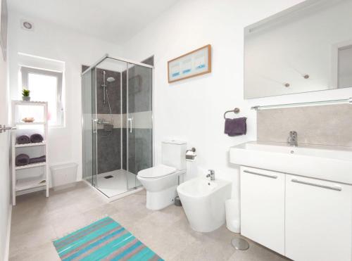 a white bathroom with a toilet and a shower at Room in Studio - Apatrment Fantastico 4 - Puerto de la Cruz - Tenerife in Puerto de la Cruz