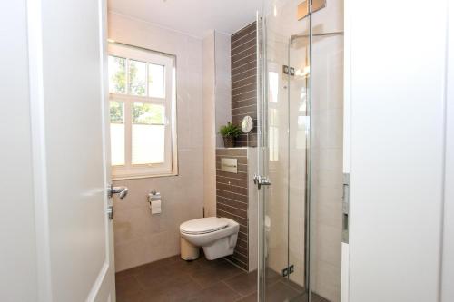 a bathroom with a toilet and a glass shower at Darß Idyll in Prerow