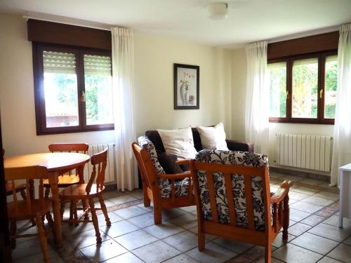 sala de estar con sofá, mesa y sillas en Finca La Cuesta, en Cangas de Onís