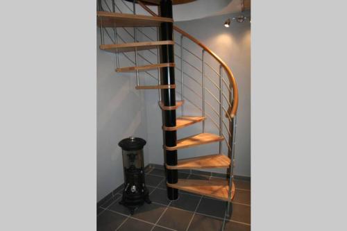 a spiral staircase in a room with a wall at Le Chalet du bonheur , individuel avec belle vue in Laveline