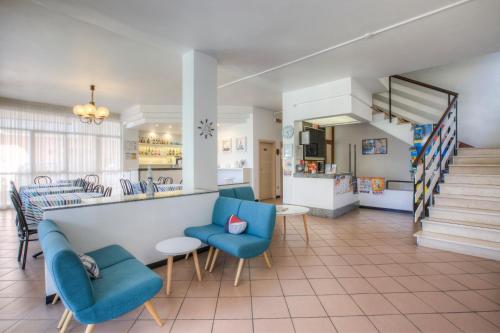 - un hall avec des chaises bleues et un comptoir dans l'établissement Hotel Belmar, à Rimini