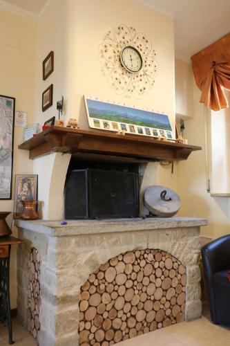 a stone fireplace with a clock on the wall at Monti Azzurri in Montemonaco