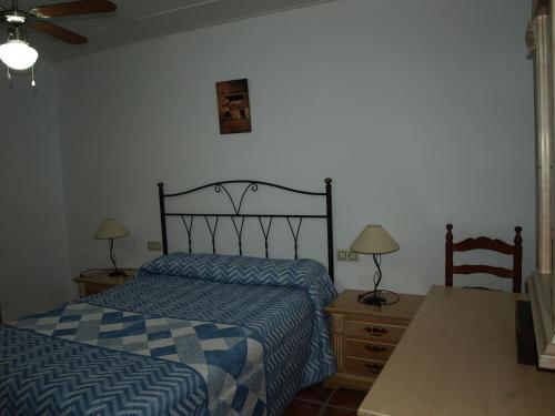 1 dormitorio con cama, escritorio y mesa con 2 lámparas en Alojamiento Rural Las Zagalas, en Tíscar