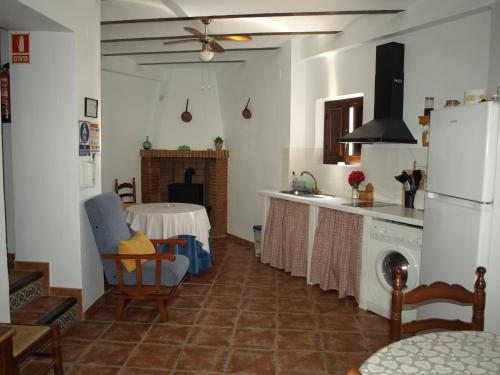 cocina con mesa y nevera blanca en Alojamiento Rural Las Zagalas, en Tíscar