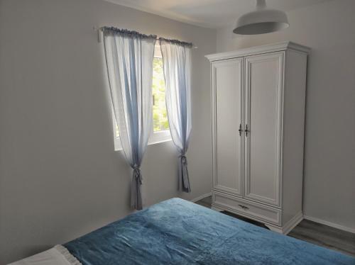 ein Schlafzimmer mit einem Bett, einer Kommode und einem Fenster in der Unterkunft Feel Dugi Otok - Apartment Sofia in Luka