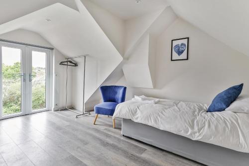 een slaapkamer met een bed en een blauwe stoel bij Newly Renovated 3 Bed Apartment with Parking by Ark SA in Sheffield