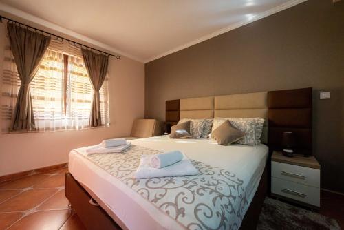 a bedroom with a large bed with two towels on it at Milas Trojica Kotor in Kotor