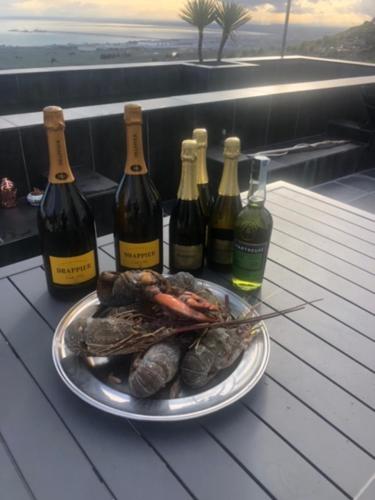 a plate of food on a table with bottles of wine at Villa Francesca - Manfredi Homes&Villas in Monte SantʼAngelo
