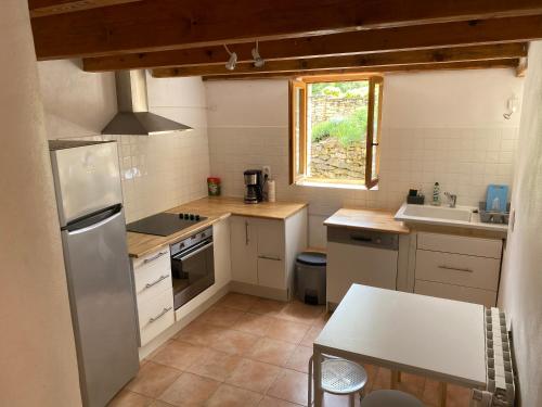 une petite cuisine avec un réfrigérateur et un évier dans l'établissement Mas de Taumassou, à Carsan