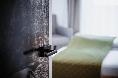 a room with a bedroom with a bed and a chair at Die Waldruhe in Kartitsch
