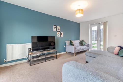 a living room with a couch and a tv at Liberty House - Perfect for Contractors - 2 Off-Road Parking Spaces in Wolverhampton