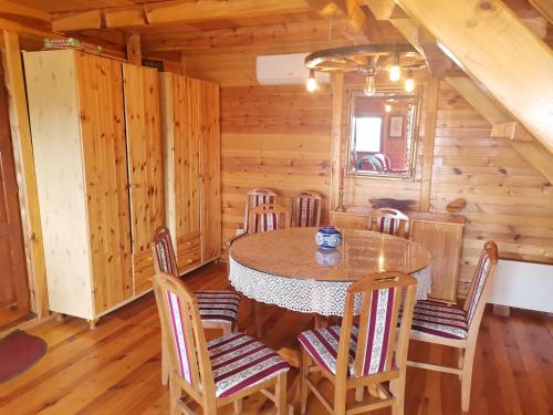 a dining room with a table and chairs in a cabin at Careva voda 1 in Dobroselica