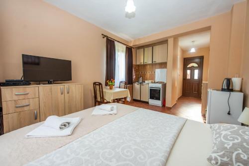 a bedroom with a large bed with a flat screen tv at Milas Trojica Kotor in Kotor