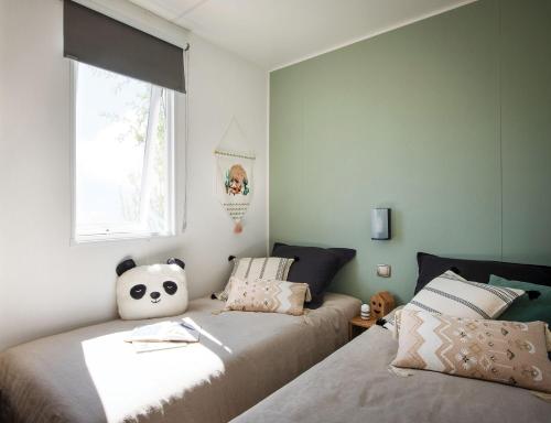 a bedroom with two beds and a window at Domaine Sainte Veziane in Bessan