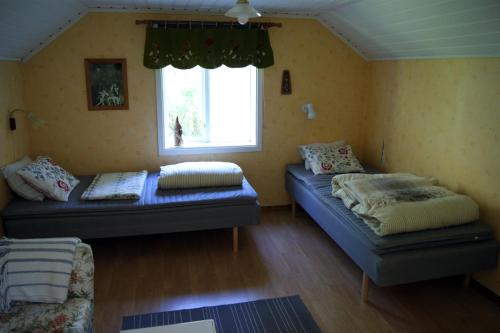 a living room with two beds and a window at Karlsäter - Stora stugan in Älvkarleby