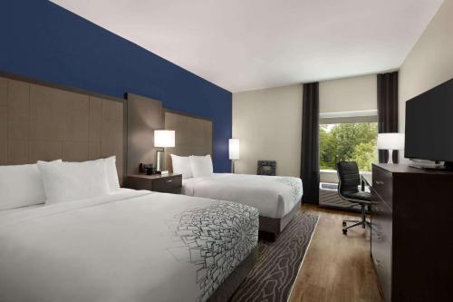 a hotel room with two beds and a television at La Quinta by Wyndham Rock Hill in Rock Hill