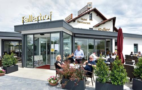 a group of people sitting at a table outside a restaurant at Hotel Restaurant Fallerhof in Bad Krozingen