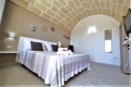 a bedroom with a white bed with a stone ceiling at Villa Stella in Marina di Pescoluse