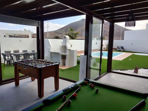 stół bilardowy w salonie z widokiem na podwórko w obiekcie Villa Lanzarote Deluxe & Spa Pool w mieście Playa Blanca