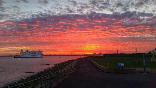 a sunset over the water with a cruise ship at Florence House Boutique Hotel and Restaurant in Portsmouth