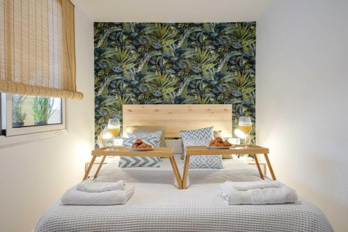 a bedroom with a bed with a table and glasses of wine at Castelldefels Beach&Fun in Castelldefels