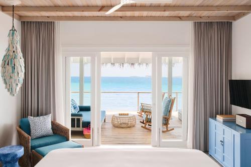 a living room filled with furniture and a window at Finolhu Baa Atoll Maldives in Baa Atoll