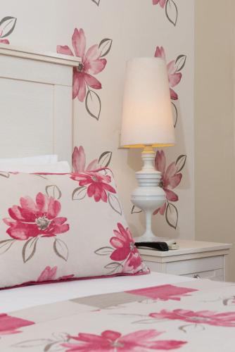 a bedroom with a bed with pink flowers on the wall at Louloudis Boutique Hotel in Skala Rachoniou