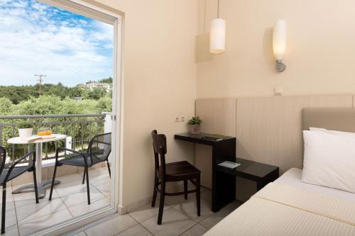 a bedroom with a bed and a balcony with a table and chairs at Louloudis Boutique Hotel in Skala Rachoniou