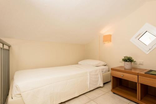 a bedroom with a white bed and a table at Louloudis Boutique Hotel in Skala Rachoniou