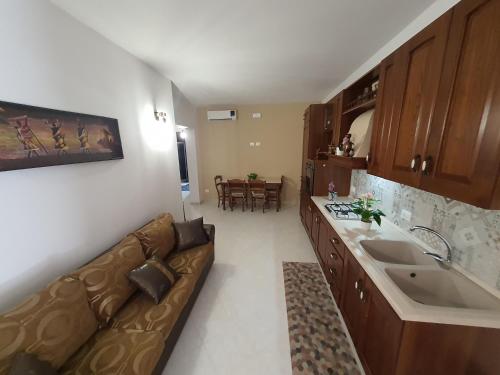 a living room with a couch and a kitchen at Appartamento MariaLuisa in Marsala