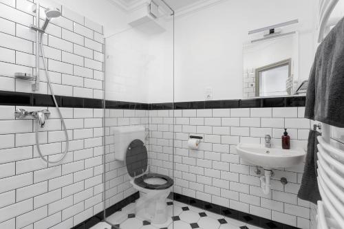 La salle de bains blanche est pourvue de toilettes et d'un lavabo. dans l'établissement Premium Vendégház, à Eger