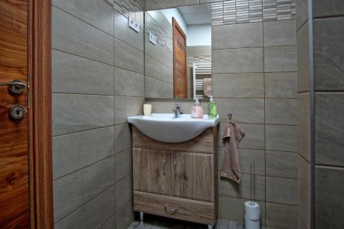 uma casa de banho com um lavatório e um espelho em Bodzaház Apartman em Tarján