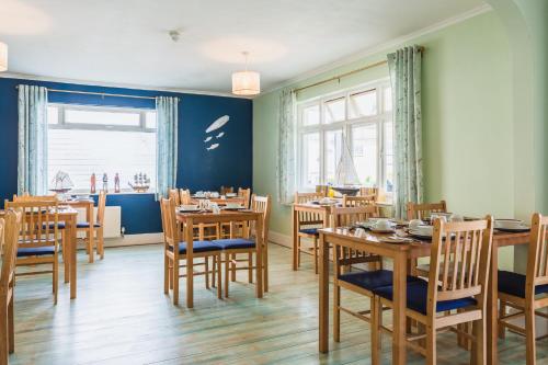 a dining room with wooden tables and chairs at The Royson Guest House in Shanklin