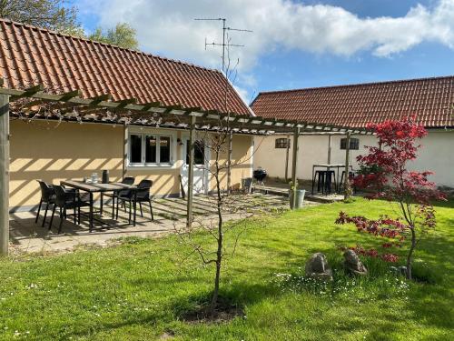 ein Haus mit einem Tisch und Stühlen im Hof in der Unterkunft BRICK Österlen in Simrishamn