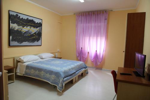 una camera con letto, scrivania e TV di Casa Nazzaro a Benevento