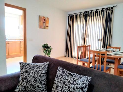 ein Wohnzimmer mit einem Sofa und einem Tisch in der Unterkunft ACV - Isla Park-1ª Linea Planta 9 Frontal Interior in Oropesa del Mar
