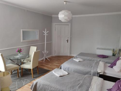a room with two beds and a table with chairs at Sleep Well in Poznań