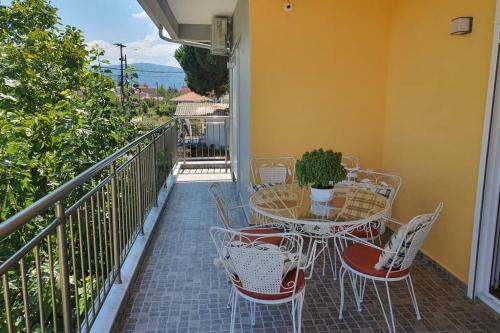 a patio with a table and chairs on a balcony at Villa Fer Forze you have the feeling of your own holiday home in Asprovalta