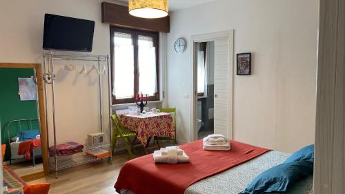 ein Schlafzimmer mit einem Tisch und einem Bett mit einer roten Decke in der Unterkunft Il Gatto e il Cocker in Verona