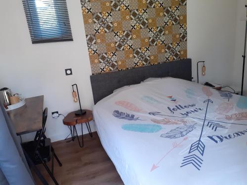 una camera da letto con un letto con un piumone di Chambre cosy calme proche aéroport, Groupama Stadium, CNPE BUGEY, Eurexpo a Chavanoz