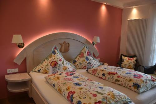 a bedroom with a bed with a headboard and pillows at Gastinger Hotel-Restaurant in Schmiedefeld am Rennsteig