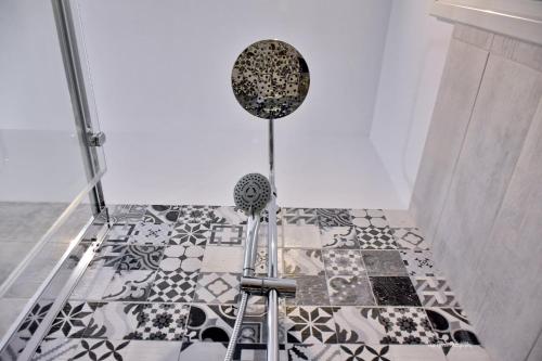 a bathroom with a shower with black and white tiles at Althea Village House in Akhladherí