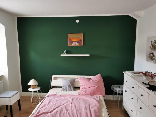 a green bedroom with a bed and a green wall at Im Herzen des Kraichgaus 1 in Östringen
