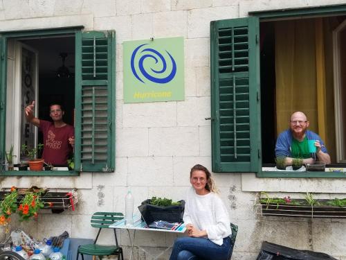 a woman sitting in a chair in front of a window at Hurricane Hostel in Split